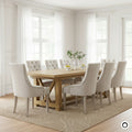 Set of 4 Antoinette high-back dining chairs in cream linen with diamond tufting and distressed oak legs in a grand dining room.
