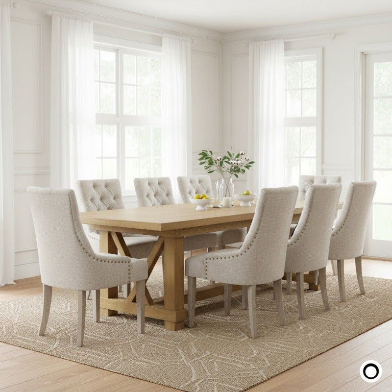 Set of 4 Antoinette high-back dining chairs in cream linen with diamond tufting and distressed oak legs in a grand dining room.