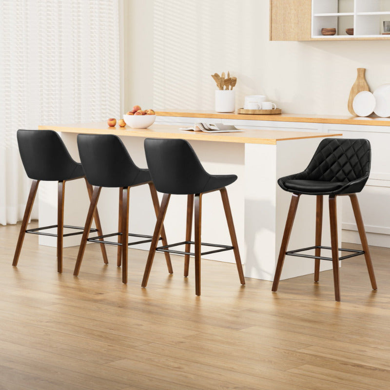 Set of 4 Bentwood diamond-stitch bar stools with black leather seats and walnut legs at a modern kitchen island.