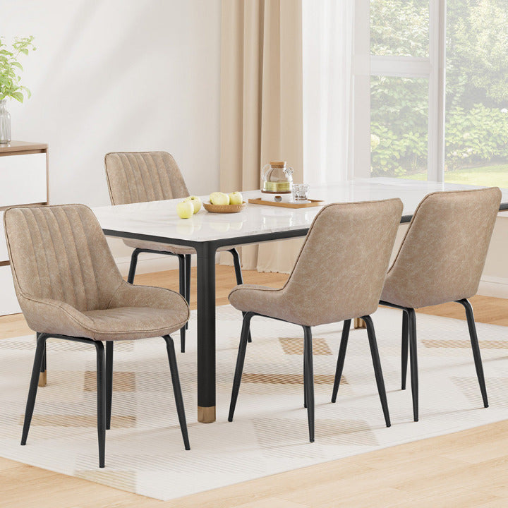 Set of 4 Hudson mid-century dining chairs in khaki tan vegan leather with channel tufting around a modern dining table.